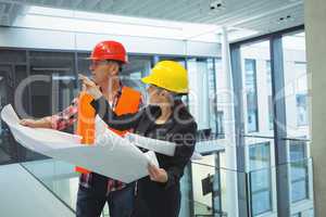 Businesswoman discussing over blueprint with an architect