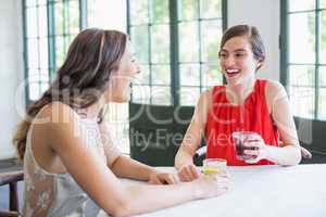 Friends laughing while having cocktails