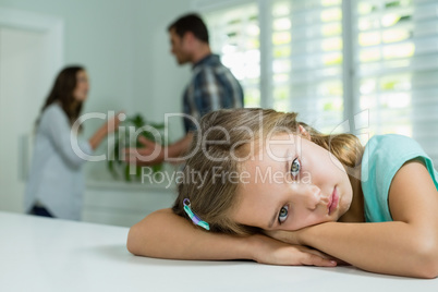 Sad girl resting on table in living room at home