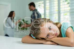 Sad girl resting on table in living room at home