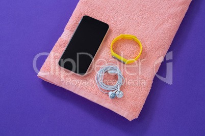 Towel with mobile phone, headphones and fitness band