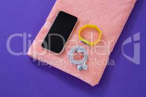 Towel with mobile phone, headphones and fitness band