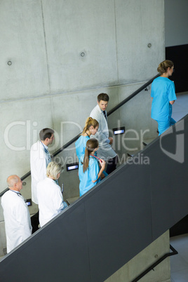 Group of doctors and surgeons interacting with each other on staircase