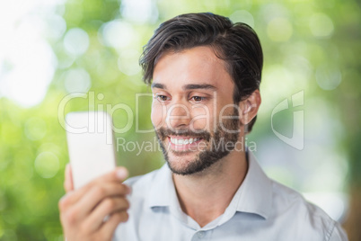 Man smiling while using his mobile phone