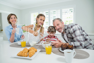 Smiling family having breakfast in the kitchen