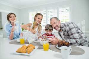 Smiling family having breakfast in the kitchen