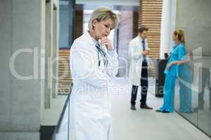 Thoughtful female doctor standing n corridor