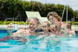 Smiling man taking selfie with family in swimming pool