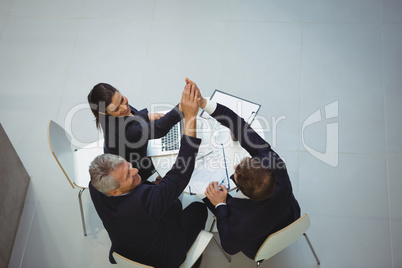 Businesspeople giving a high five to each other