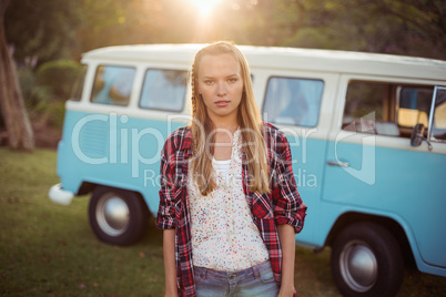 Portrait of woman standing near campervan