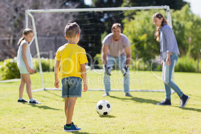 Happy family playing football in the park