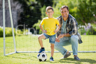Father and son with football in the park on a sunny day