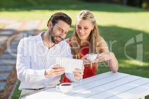 Happy couple having coffee and using digital tablet