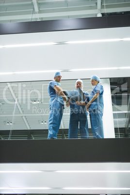 Team of surgeons discussing x-ray in corridor