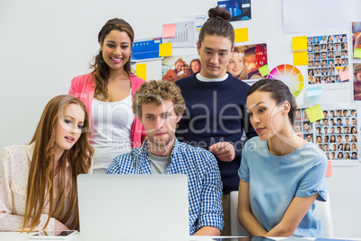 Executives discussing over laptop in office