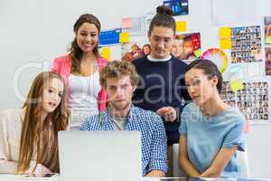 Executives discussing over laptop in office