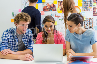 Executives discussing over laptop in office