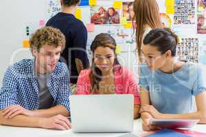 Executives discussing over laptop in office