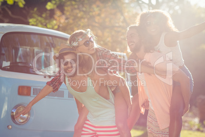 Two couples having piggy ride in park