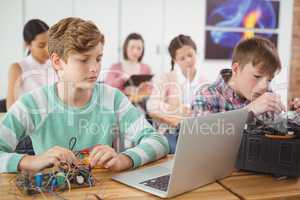 Schoolboys working on electronical project in classroom