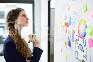 Thoughtful woman looking at adhesive notes