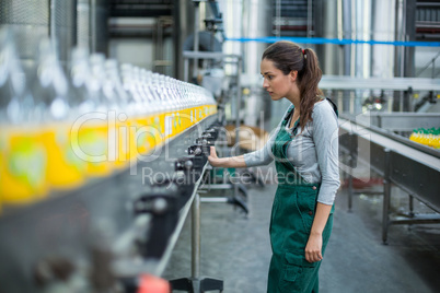 Female factory worker standing near production line