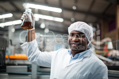 Factory engineers holding a sample of drink