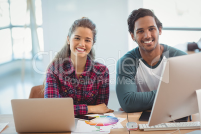 Male and female graphic designers sitting at desk Male and female graphic designers sitting at desk