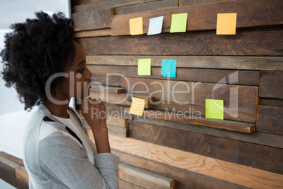 Female graphic designer looking at sticky notes