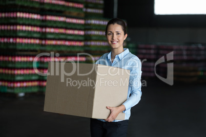 Female factory worker carrying cardboard boxes in factory