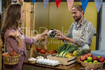 Woman making a payment by using NFC technology