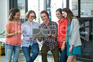 Business executives discussing over laptop