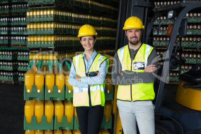 Factory workers standing with arms crossed in factory
