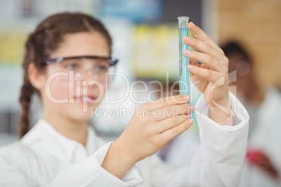 Schoolgirl experimenting molecule model in laboratory at school