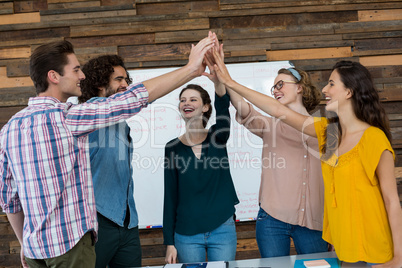 Business executives giving high five in office