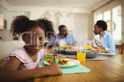 Portrait of girl having meal on dining table