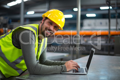 Factory worker using laptop