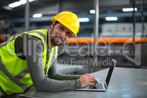 Factory worker using laptop