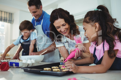 Happy family preparing cookies in kitchen