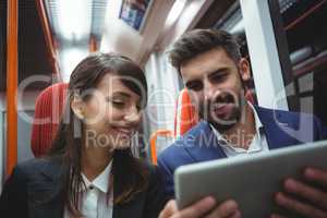 Executives using digital tablet travelling in train