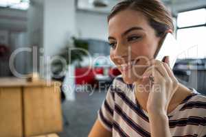 Smiling female graphic designer talking on mobile phone