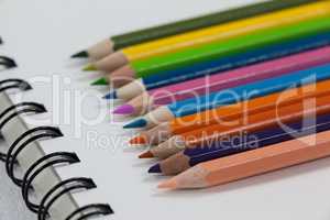 Close-up of colored pencils and notebook