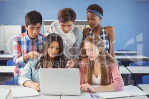 Group of students using laptop in classroom