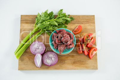 Minced beef and ingredients on wooden tray