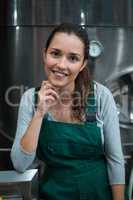 Female factory worker standing at drinks production factory