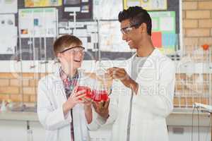Smiling school kids doing a chemical experiment in laboratory