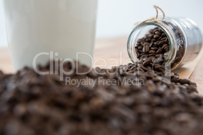 Close-up of coffee beans spilling out of jar