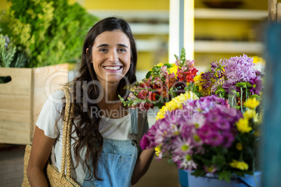 Smiling woman selecting flowers at florist shop