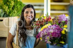 Smiling woman selecting flowers at florist shop