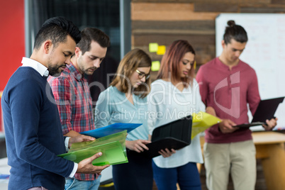 Business executives looking over file in office